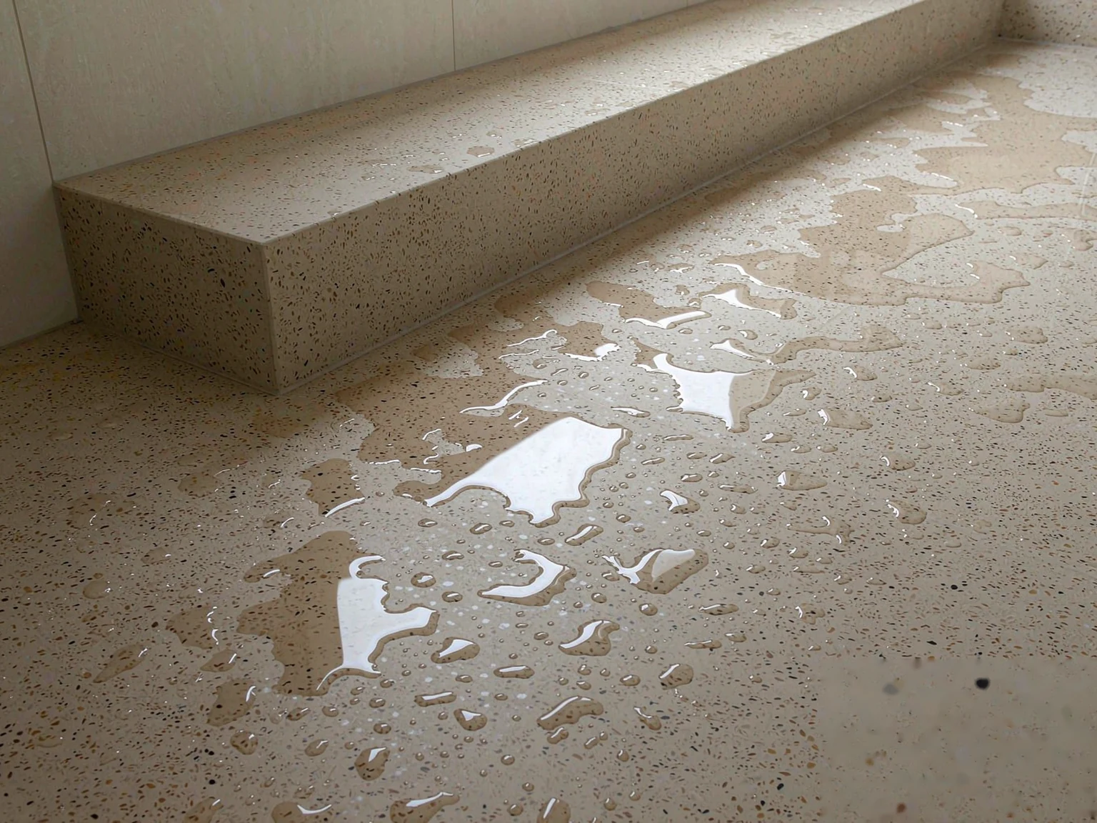 Sintered stone shower floor and bench in a bathroom wet zone